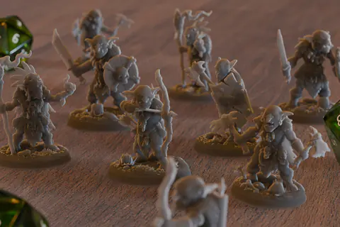 Figurines fantastiques grises non peintes à côté de dés de jeu